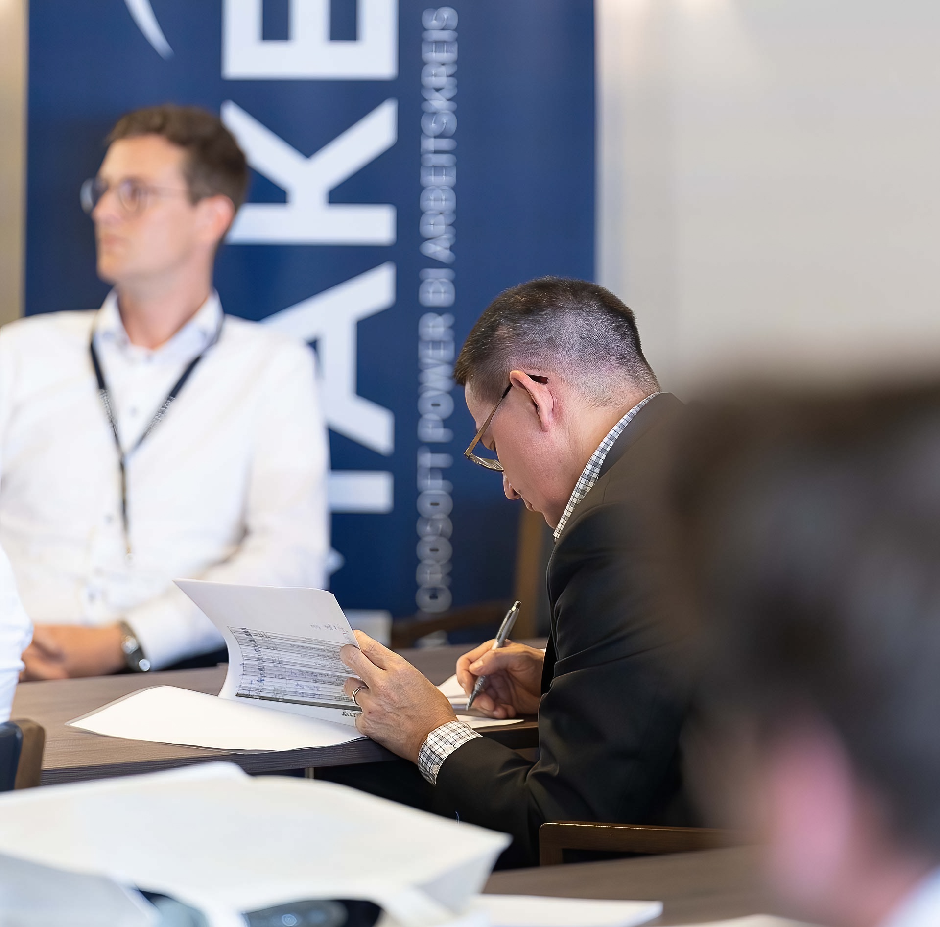 Interested participants take notes at MAKE BI 2022 by IT Logix AG